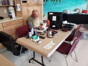 Volunteer at table fixing items