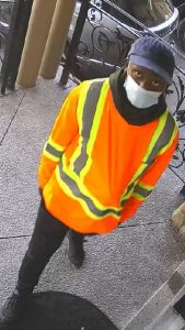 Suspect in orange vest and mask