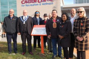 Group standing together at plaque